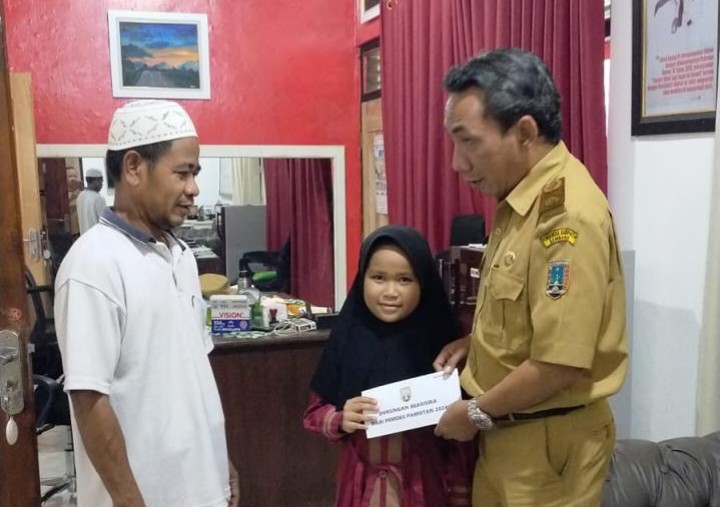 Kades Pamotan Ahmad Masykur Rukhani tengah memberikan bantuan sosial kepada warga yang membutuhkan